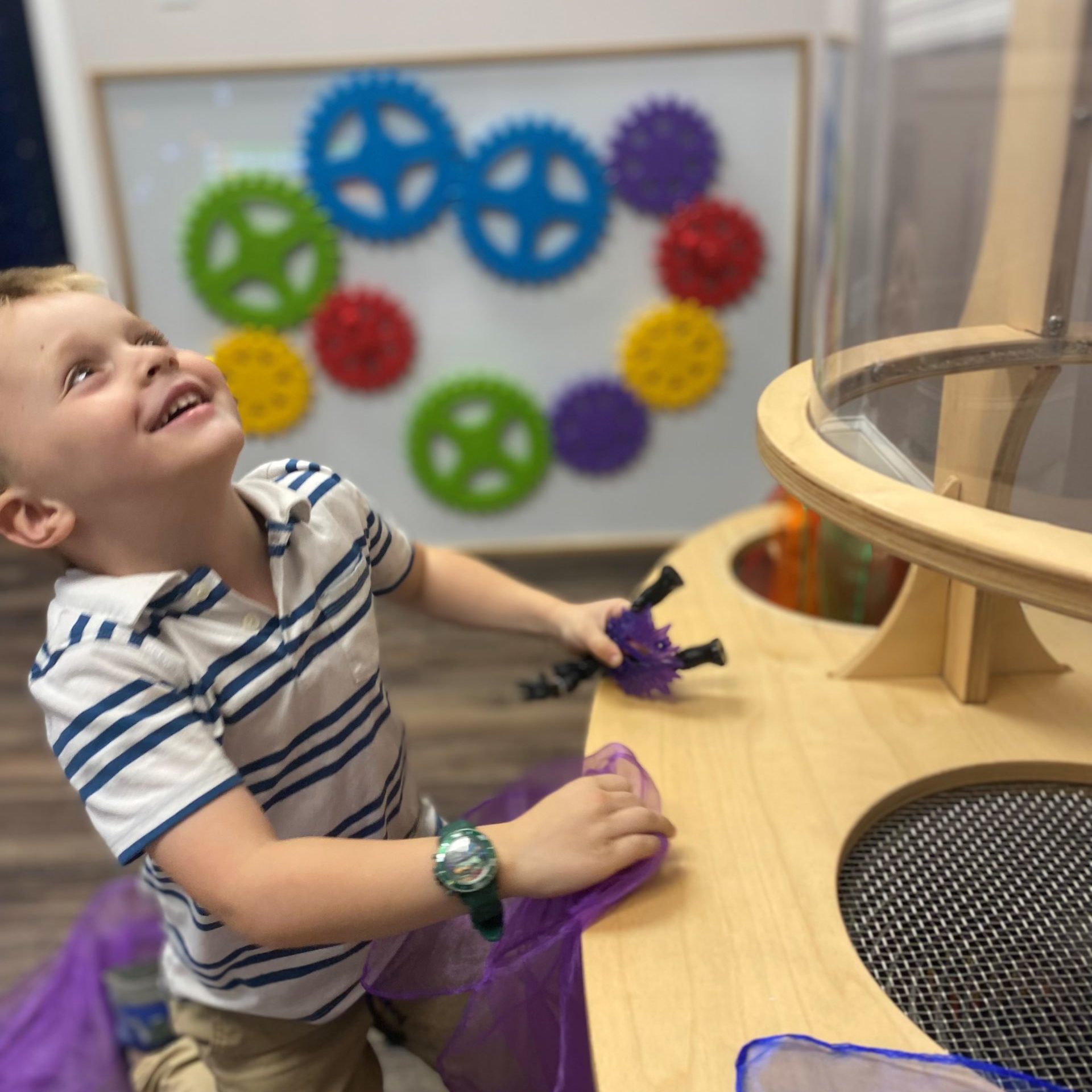 A young boy watches scarfs carried up through the wind tunnel into the air in the STEM room at the North Shore Children's Museum in Peabody, MA