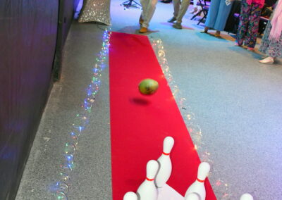 A man throwing a ball towards bowling pins