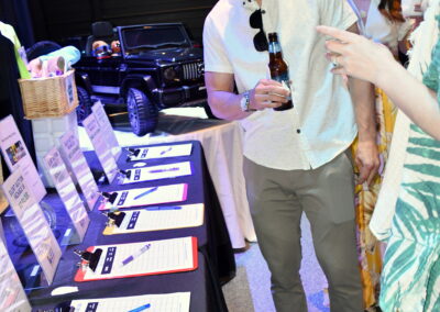 A man smiling for the camera in front of the silent auction table