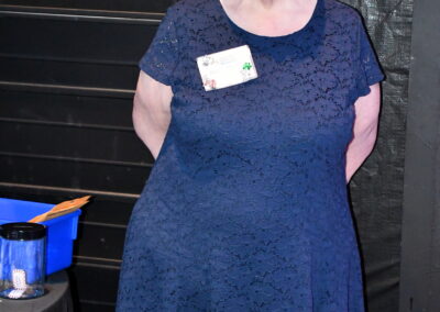 An older woman post in front of a table for the grown ups gala