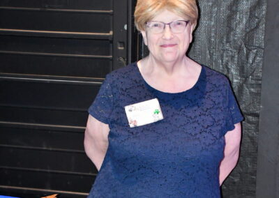 An older woman post in front of a table for the grown ups gala