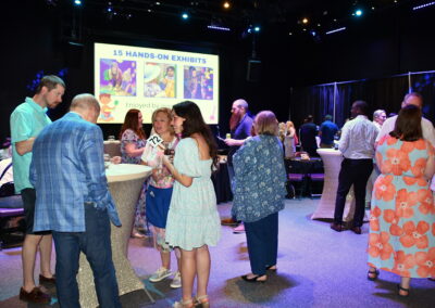 A group of adults around cocktail tables for the grown ups gala to support NSCM
