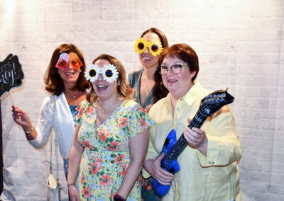 4 ladies using photobooth props to take a photo